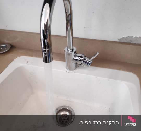 ברז מים זורמים בכיור לבן